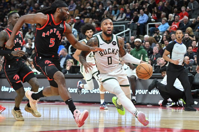 Nov 15, 2023; Toronto, Ontario, CAN; Milwaukee Bucks guard Damian Lillard (0) drives toward the basket past Toronto Raptors forward Precious Achiuwa (5) in the second half at Scotiabank Arena. Mandatory Credit: Dan Hamilton-USA TODAY Sports