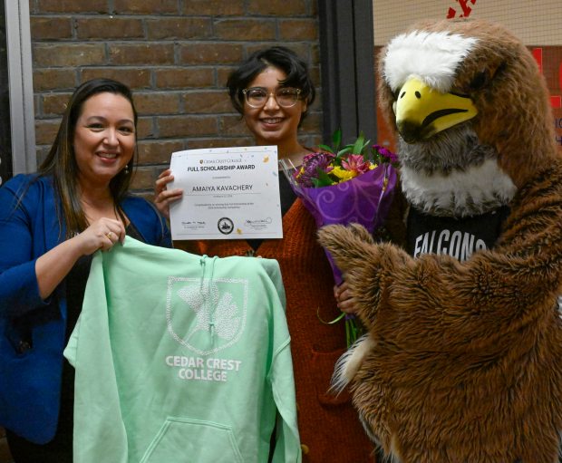 Stephanie Walker, Cedar Crest Vice President of Enrollment holds a Cedar Crest Hoodie next to Amaiya Kavachery a student at Lehigh Career Technical Institute who is awarded a full-tuition scholarship as the winner of Cedar Crest College's annual Scholarship Competition. The reveal was held at the LCTI on Tuesday, April 9, 2024. (Monica Cabrera/The Morning Call)