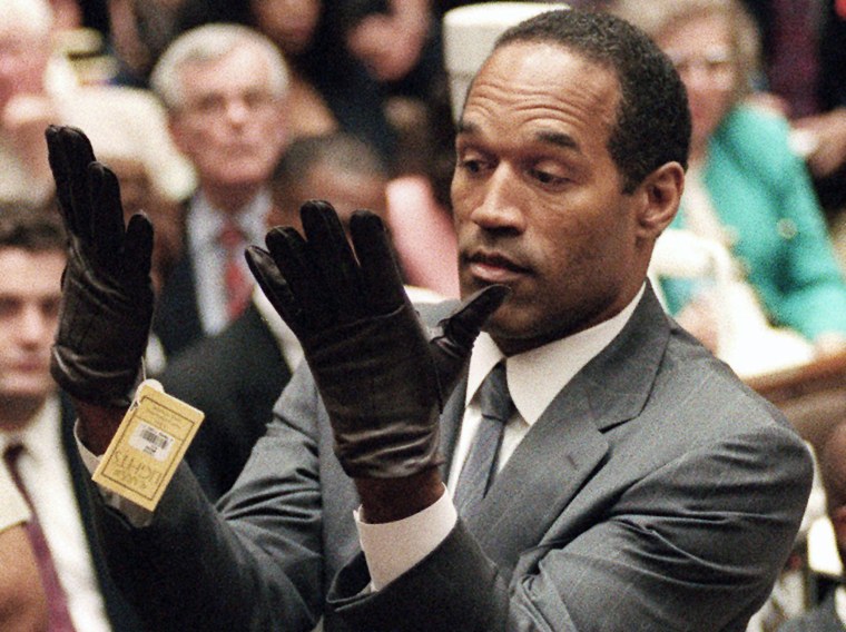 O.J. Simpson holds up his hands before the jury after putting on a new pair of gloves similar to the infamous bloody gloves during his double-murder trial in Los Angeles on June 21, 1995.