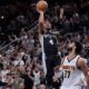 San Antonio Spurs guard Devonte' Graham (4) scores the winning shot over Denver Nuggets guard Jamal Murray (27) during the second half of an NBA basketball game in San Antonio, Friday, April 12, 2024. (AP Photo/Eric Gay)