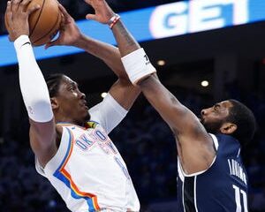 The Oklahoma City Thunder's Jalen Williams goes up for a basket as the Dallas Mavericks' Kyrie Irving (11) defends.