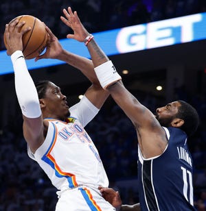 The Oklahoma City Thunder's Jalen Williams goes up for a basket as the Dallas Mavericks' Kyrie Irving (11) defends.
