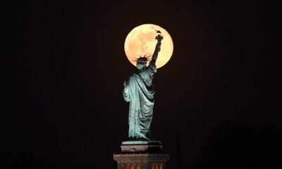 May's full Moon, known as the full flower moon, rises behind the Statue of Liberty on May 7, 2020, in New York City.