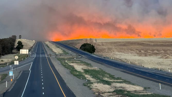 Bright orange flames from the Corral Fire can been seen near I-580 in Tracy, California on Saturday, June 1, 2024.