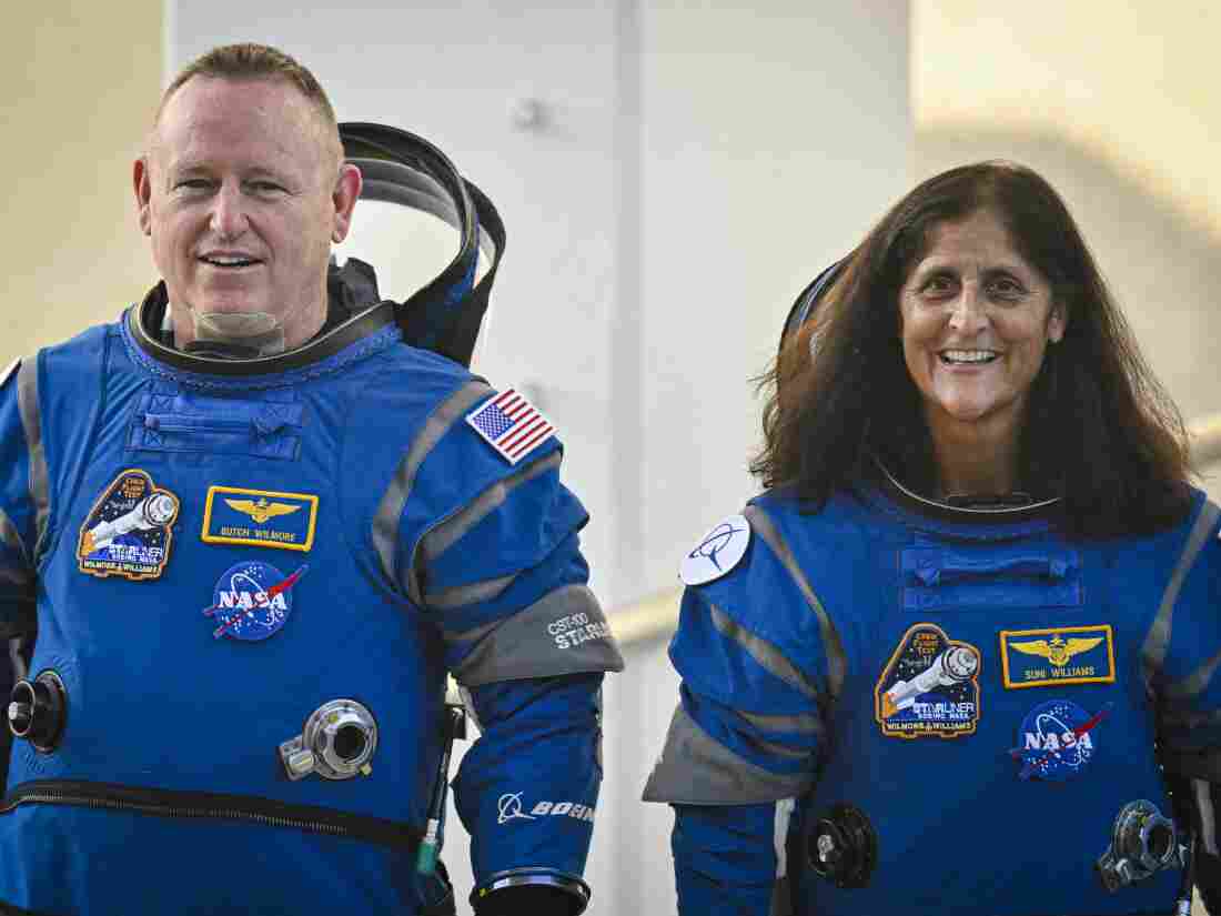 NASA astronauts Butch Wilmore (L) and Suni Williams, wearing Boeing spacesuits, as they depart the operations and checkout building for the launchpad on Wednesday at the Kennedy Space Center in Florida. It's the third trip to space for both of them.