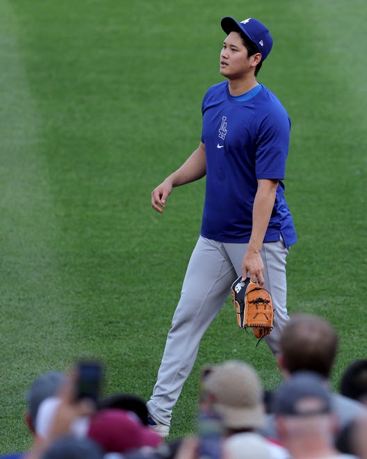 Jun 7, 2024; Bronx, New York, USA; Fans watch as Los Angeles Dodgers designated hitter Shohei Ohtani (17) throws in the outfield before a game against the New York Yankees at Yankee Stadium. Mandatory Credit: Brad Penner-USA TODAY Sports