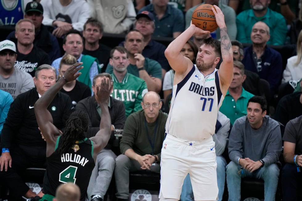 Dallas Mavericks guard Luka Doncic (77) looks to shoot over Boston Celtics guard Jrue Holiday...