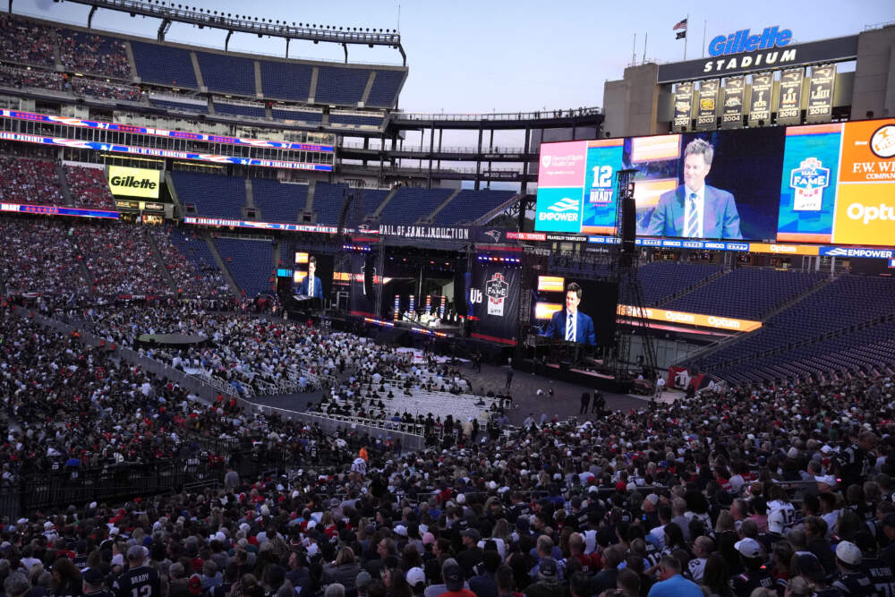 Former New England Patriots quarterback Tom Brady appears on large screens while speaking from the stage during Patriots Hall of Fame induction ceremonies. (Steven Senne/AP)