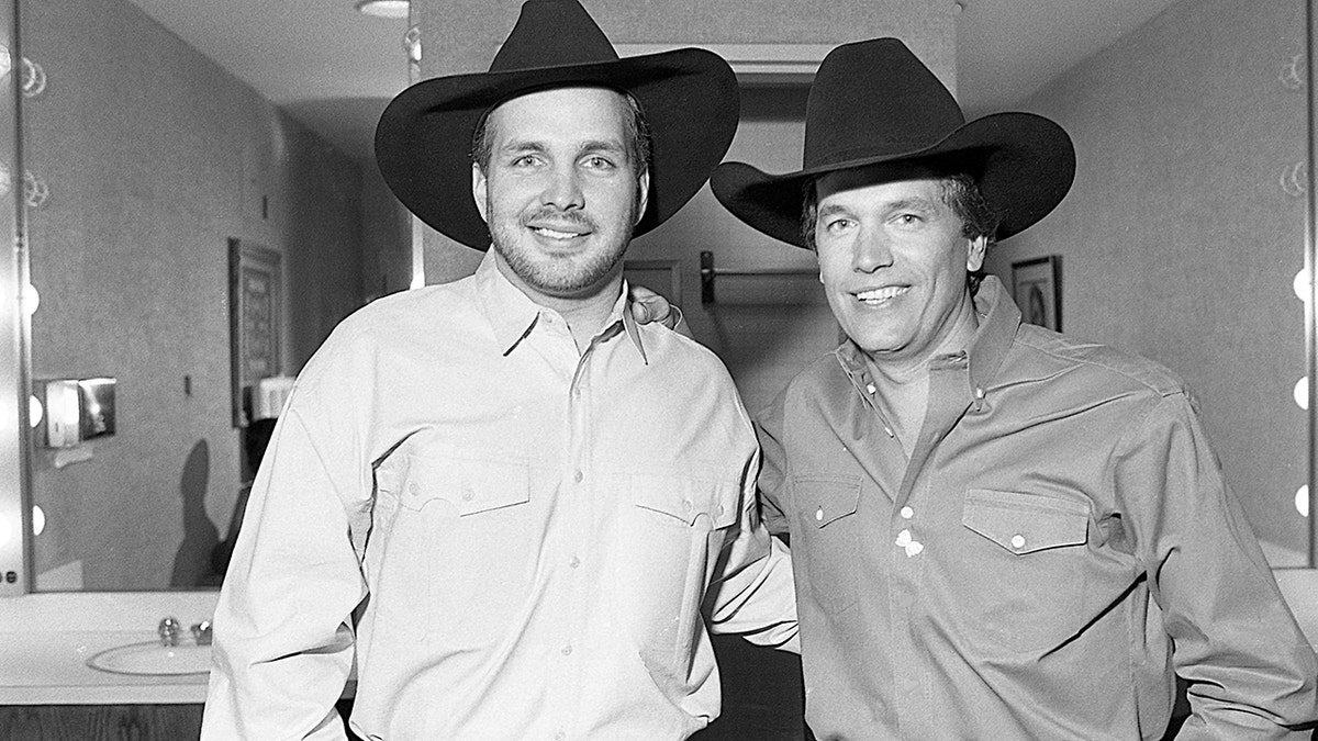 Garth Brooks and George Strait wear match black hats.