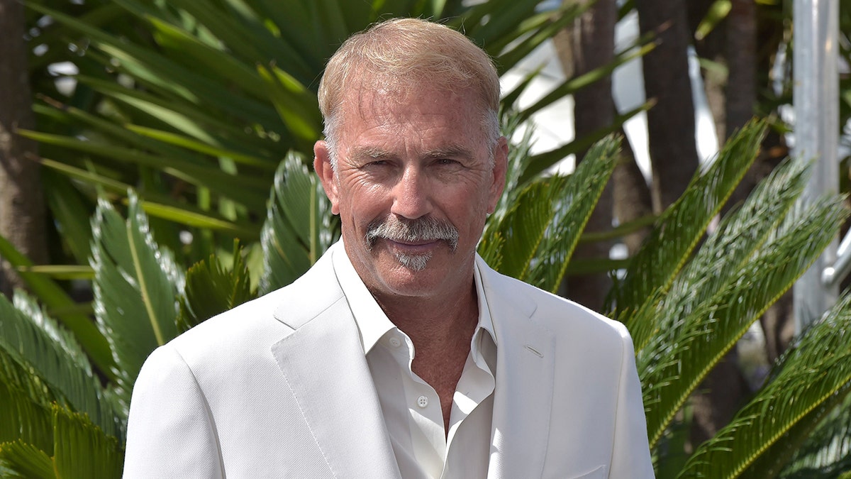 Actor Kevin Costner wears white suit at photo events in France.