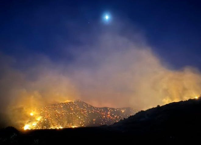 The moon shines over the Post Fire early Sunday, June 16, 2024, burning between Gorman and Pyramid Lake.