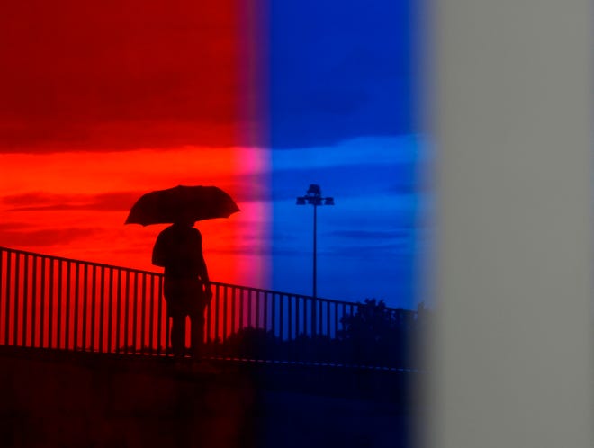 July 3, 2024; Columbus, Ohio, USA; 
A person ventures out with an umbrella at National Veterans Memorial and Museum after storms passed through downtown before Red, White and Boom on Wednesday evening.