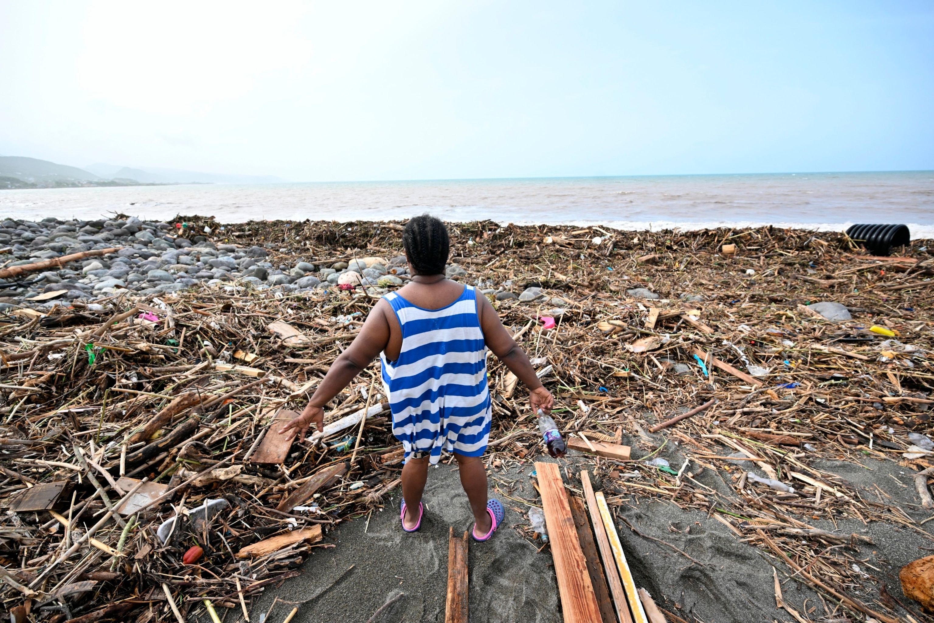 PHOTO: A woman looks at a beach littered with trash at Bull Bay, Jamaica, in the aftermath of Hurricane Beryl on July 4, 2024. 