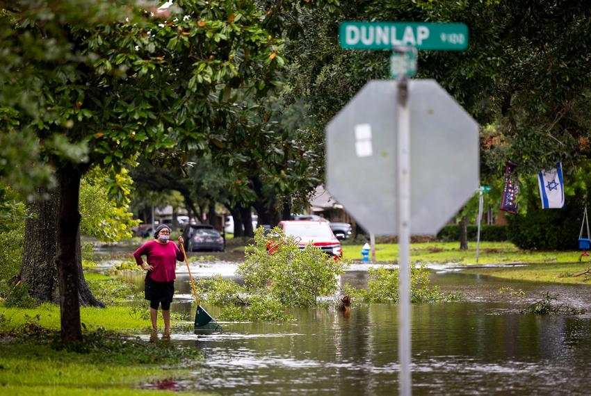 A neighbor in Robindell surveys the flooded street in front of her house after Hurricane Beryl on Monday, July 8, 2024, in Houston.