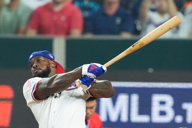 The Texas Rangers’ Adolis Garcia follows through during the MLB...