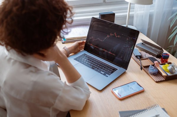 A person looking at a stock chart on a laptop.