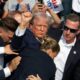 Republican candidate Donald Trump is seen with blood on his face surrounded by secret service agents as he is taken off the stage at a campaign event at Butler Farm Show Inc. in Butler, Pennsylvania, July 13, 2024. Donald Trump was hit in the ear in an apparent assassination attempt by a gunman at a campaign rally on Saturday. Sunday, Mississippi State Auditor Shad White called for U.S. Congressman Bennie Thompson to resign after one of his staffers posted support for the would be assassin.