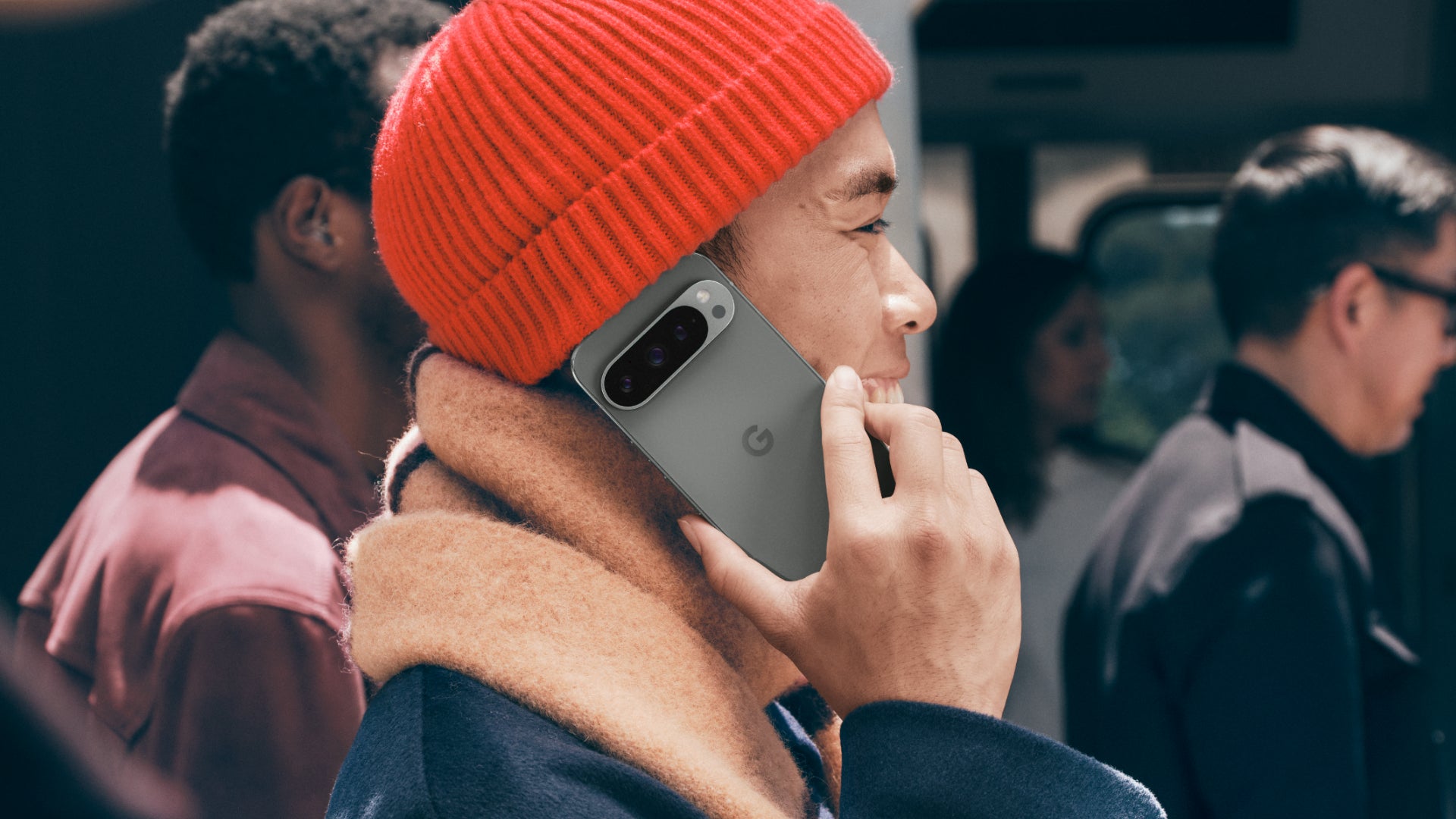 Man on a busy train platform holding the Google Pixel 9 Pro up to his ear