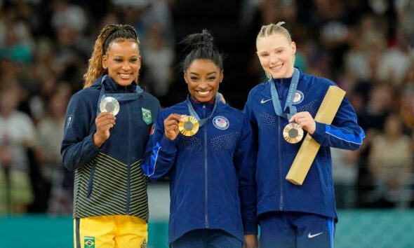 Rebeca Andrade of Brazil, Simone Biles and Jade Carey of the United States pose for a photo during the medal ceremony for the vault on the first day of gymnastics event finals during the Paris 2024 Olympic Summer Games at Bercy Arena.